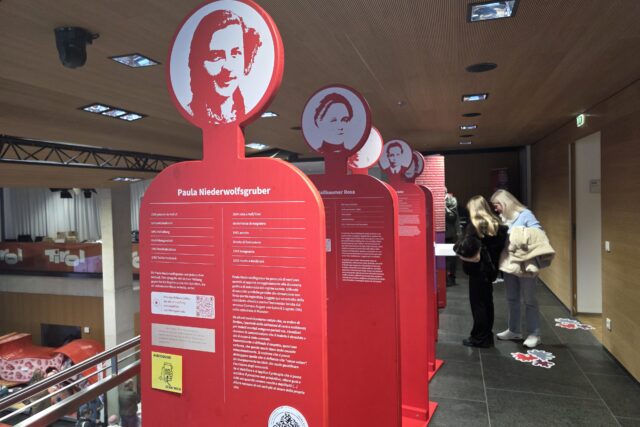 rote Ausstellungselementen, jugendliche Besucher:innen